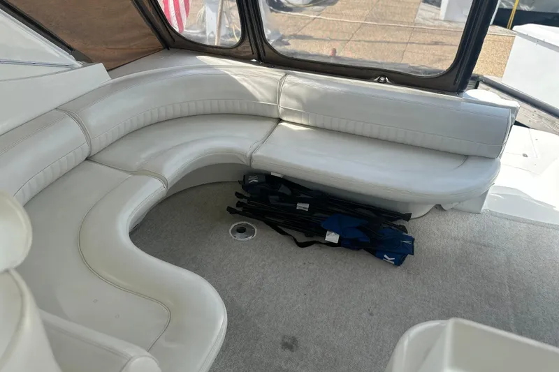 Slide: The Image of 2001 Cruisers Yachts 3870 Express interior with curved white seating and carpeted floor. - 6