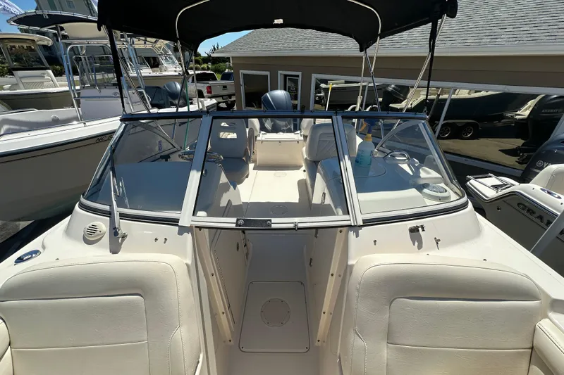 Slide: The Image of 2018 Grady-White Freedom 215 boat interior with seating and windshield, docked outdoors. - 12