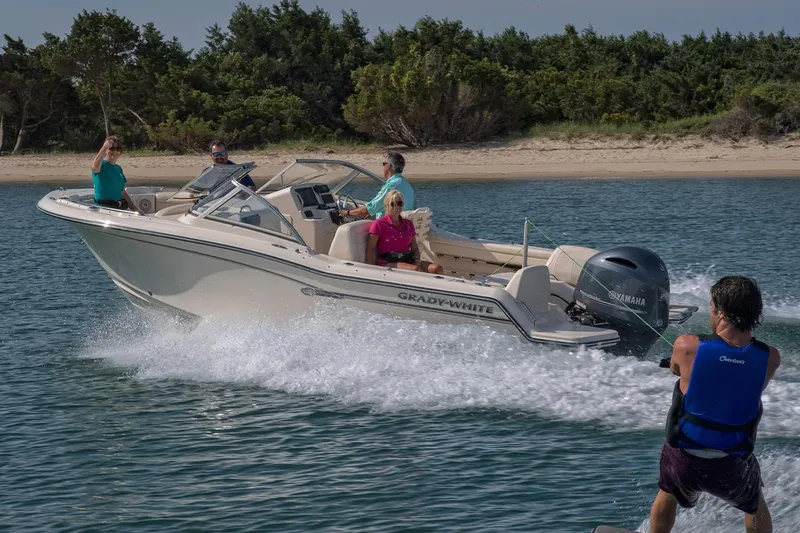 Slide: The Image of Manufacturer Provided Image: 2018 Grady-White Freedom 215 boat towing a wakeboarder near a sandy shore. - 35