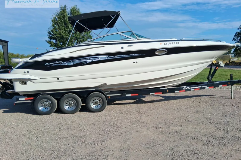 The Image of 2007 Crownline 320 LS boat on trailer, parked outdoors under clear sky. - 0