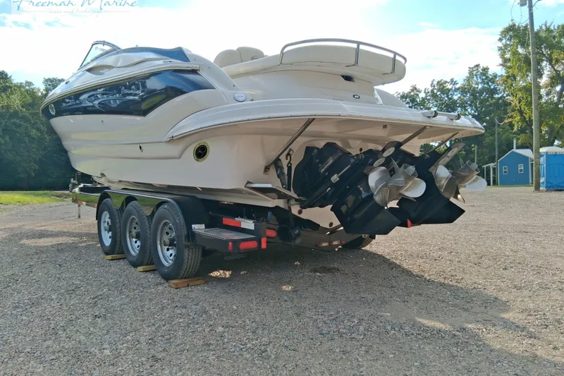 Slide: The Image of 2007 Crownline 320 LS boat on trailer, dual propellers, parked outdoors. - 1