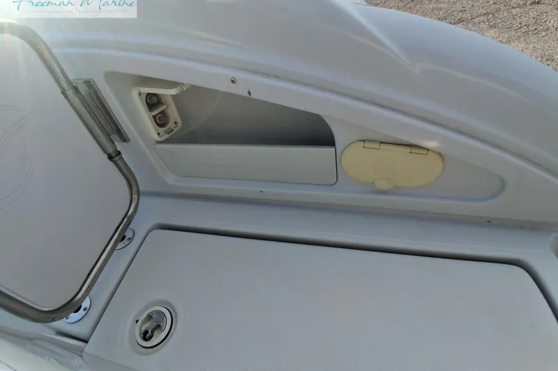 Slide: The Image of 2007 Crownline 320 LS boat storage compartment with open hatch and latch details. - 15