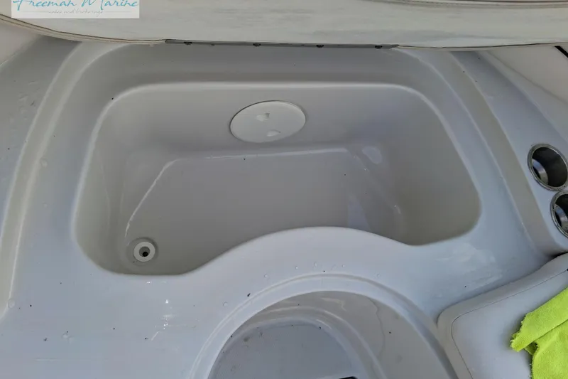 Slide: The Image of 2007 Crownline 320 LS boat sink with cup holders and green cloth. - 23