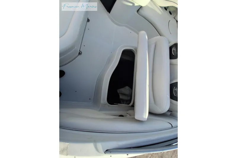 Slide: The Image of 2007 Crownline 320 LS boat interior with white seating and storage compartment. - 25