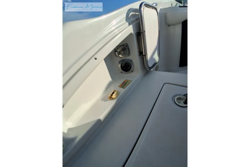 Slide: The Image of 2007 Crownline 320 LS boat interior detail with control panel and storage compartment. - 32