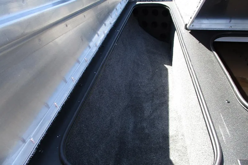 Slide: The Image of Interior storage compartment of 2026 Tracker Pro Team 175 boat, featuring carpeted lining. - 16