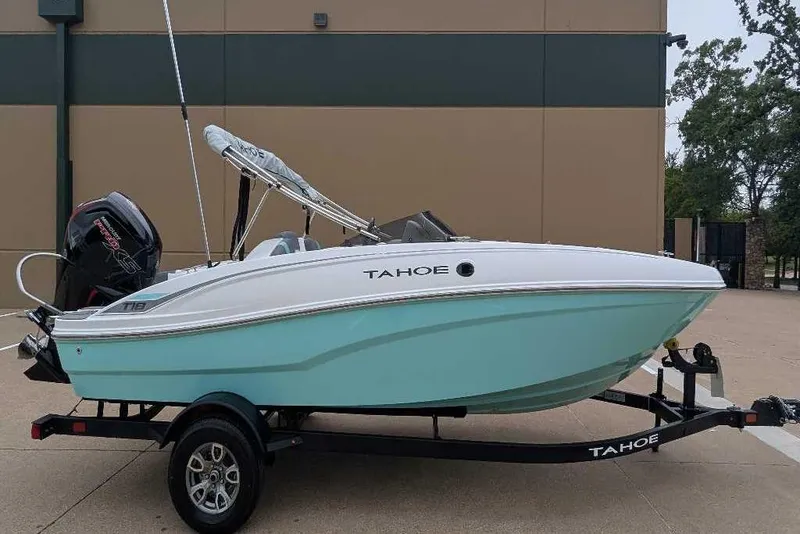 The Image of 2026 Tahoe T18 boat on trailer, light blue hull, parked outdoors. - 1