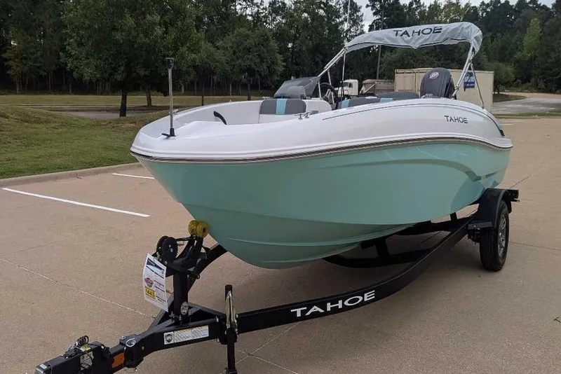 Slide: The Image of 2026 Tahoe T18 boat on trailer, parked outdoors, featuring sleek design and mint green hull. - 7
