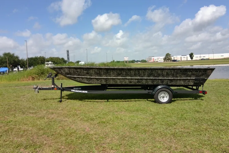 Slide: The Image of 2026 Tracker Grizzly 2072 Utility boat on trailer, parked on grassy field under blue sky. - 22