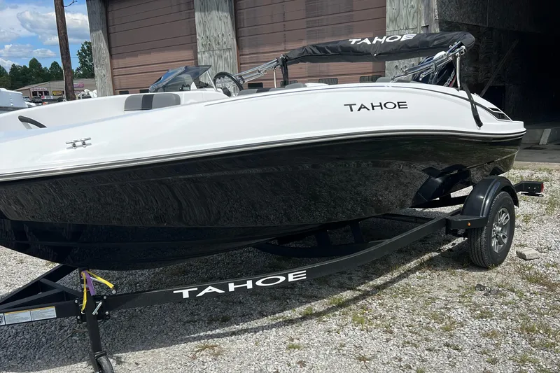 Slide: The Image of 2026 Tahoe T16 boat on trailer, white and black design, parked outdoors. - 1