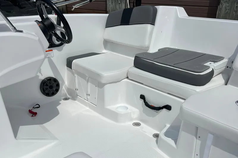 Slide: The Image of 2026 Tahoe T16 boat interior with white and gray seating, steering wheel, and cup holders. - 3