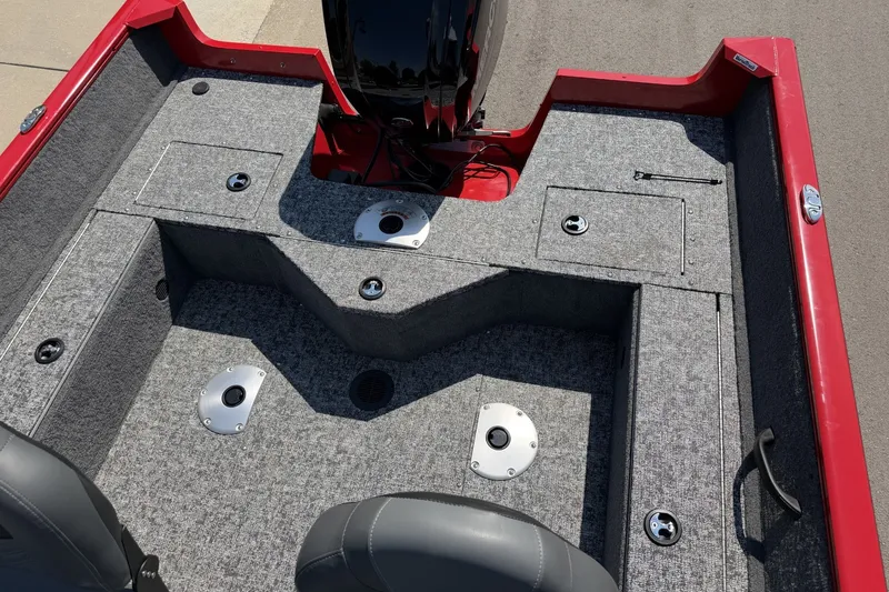 Slide: The Image of 2026 Tracker Pro Guide V-16 SC boat interior with gray carpet and storage compartments. - 18