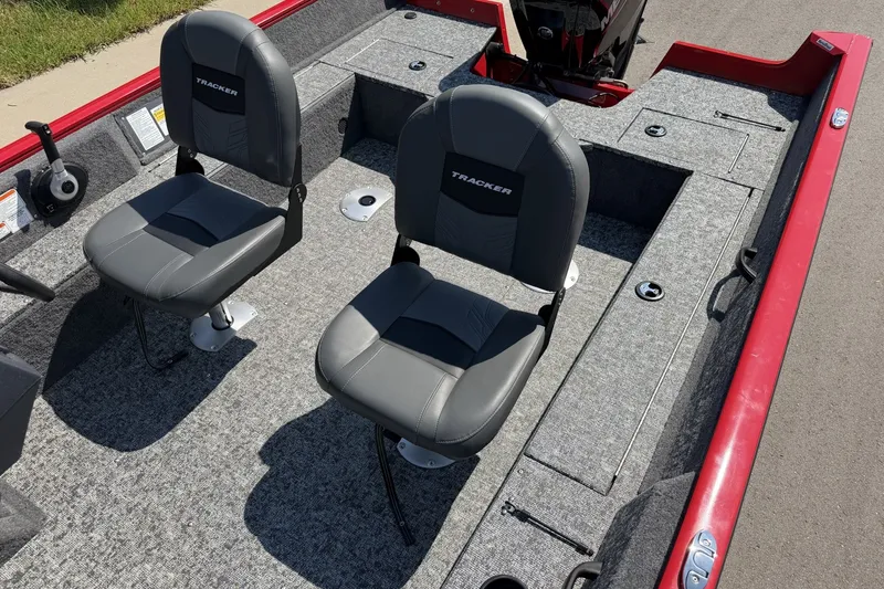 Slide: The Image of 2026 Tracker Pro Guide V-16 SC boat interior with two gray seats and red trim. - 17