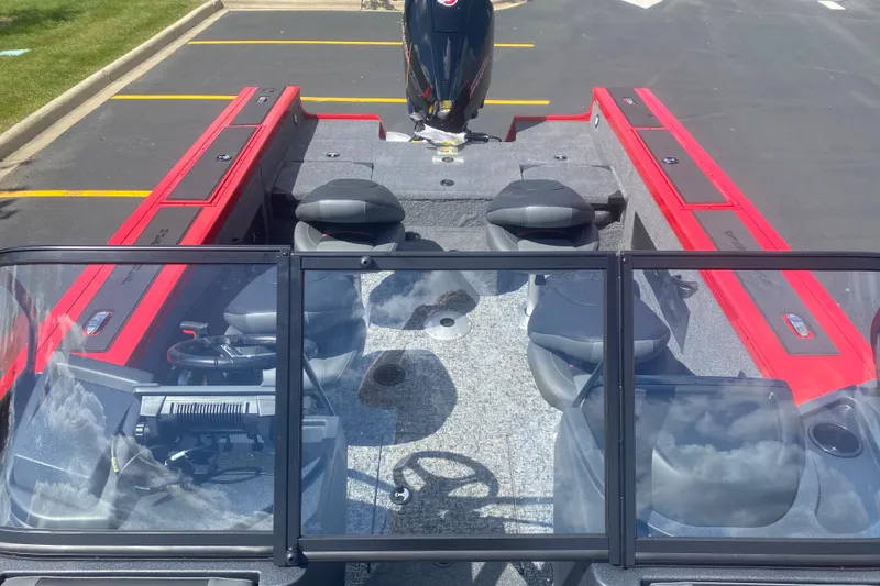 Slide: The Image of 2026 Tracker Targa V-18 Combo boat with red accents and seating, parked outdoors. - 8