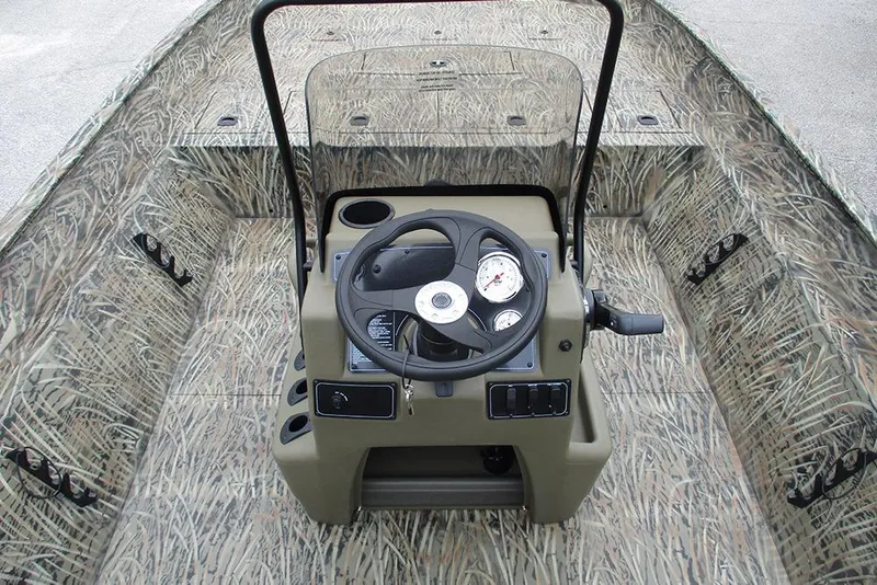 Slide: The Image of 2026 Tracker Grizzly 2072 CC boat interior with camouflage design and central steering console. - 23