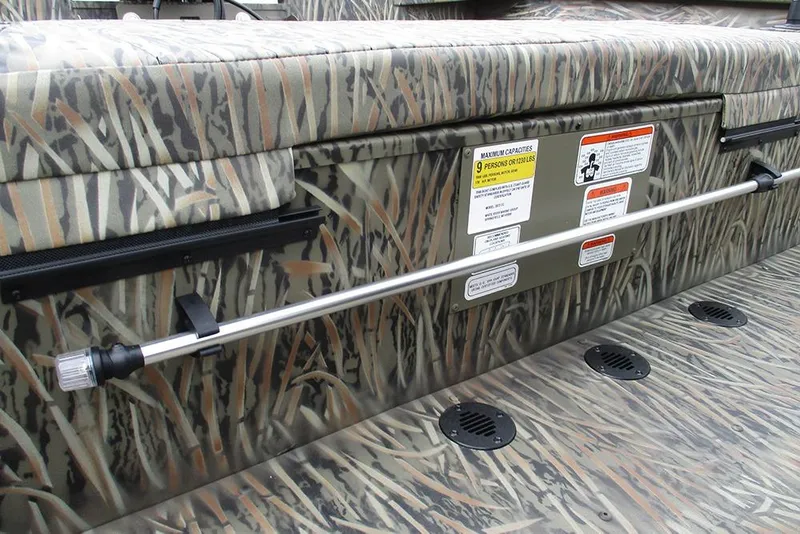 Slide: The Image of 2026 Tracker Grizzly 2072 CC boat interior with camouflage design and safety labels. - 25