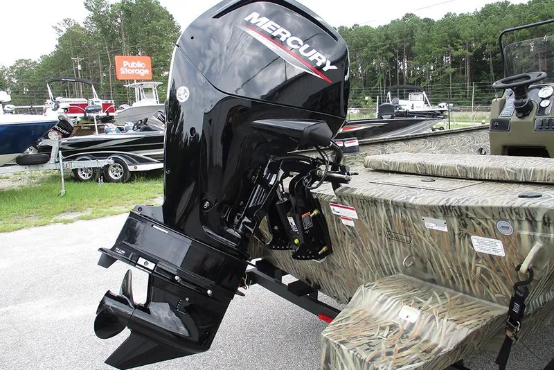 Slide: The Image of 2026 Tracker Grizzly 2072 CC boat with Mercury outboard motor, parked outdoors. - 9