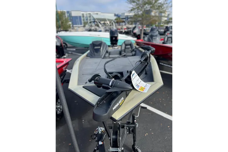 Slide: The Image of 2026 Tracker Pro Team 190 boat with Minn Kota trolling motor in a parking lot. - 2