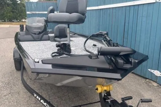 Slide: The Image of 2026 Tracker Pro 170 boat on trailer, parked by blue fence. - 1