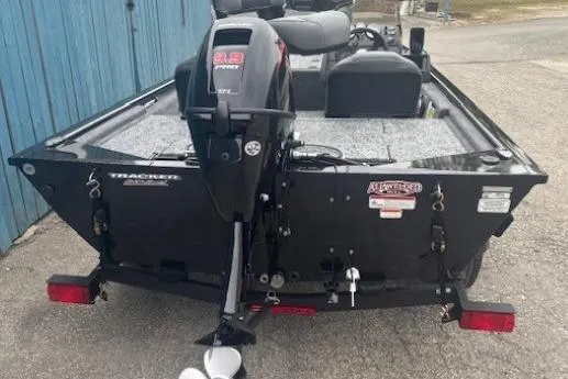 Slide: The Image of 2026 Tracker Pro 170 boat with outboard motor, parked near a blue wall. - 3