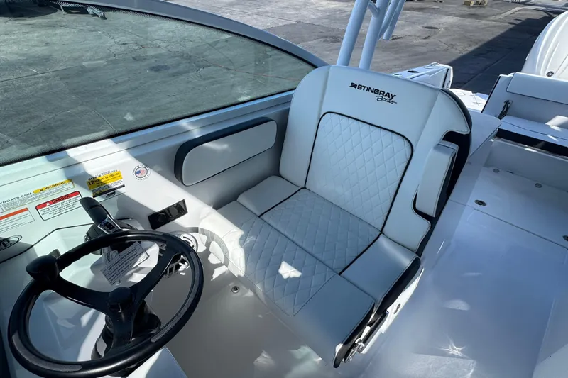 Slide: The Image of 2026 Stingray 259 DC boat interior with steering wheel and cushioned seat. - 10