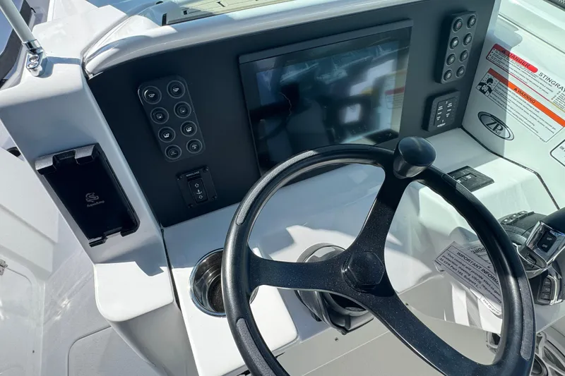 Slide: The Image of 2026 Stingray 259 DC boat dashboard with steering wheel and control panel. - 11