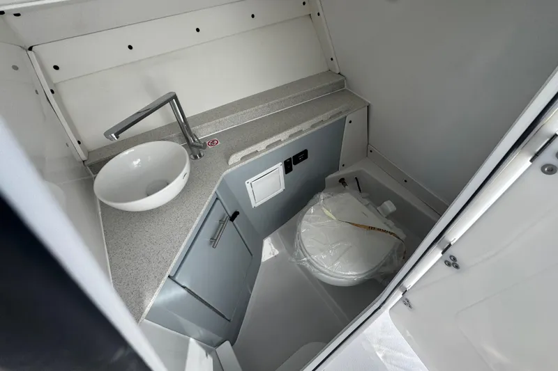 Slide: The Image of 2026 Stingray 259 DC boat interior bathroom with sink and toilet. - 14