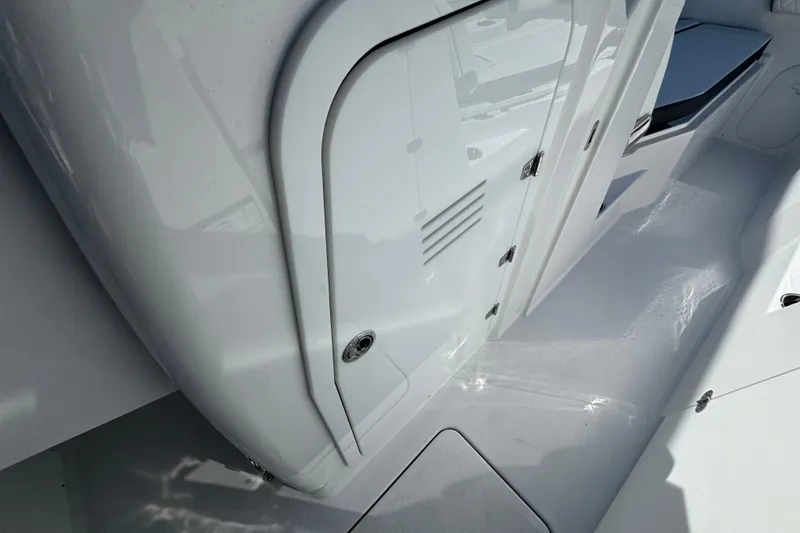 Slide: The Image of 2026 Stingray 259 DC boat interior with sleek white design and storage compartment. - 15