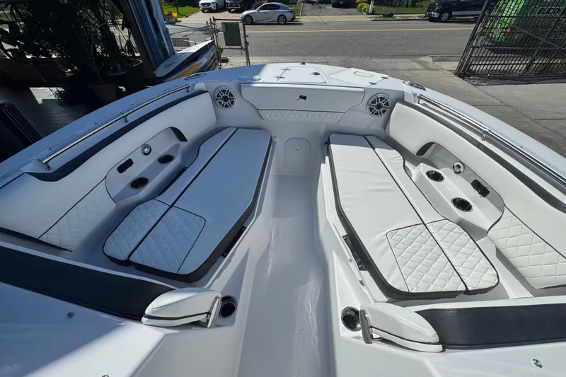 Slide: The Image of 2026 Stingray 259 DC boat interior with white seating and cup holders. - 17