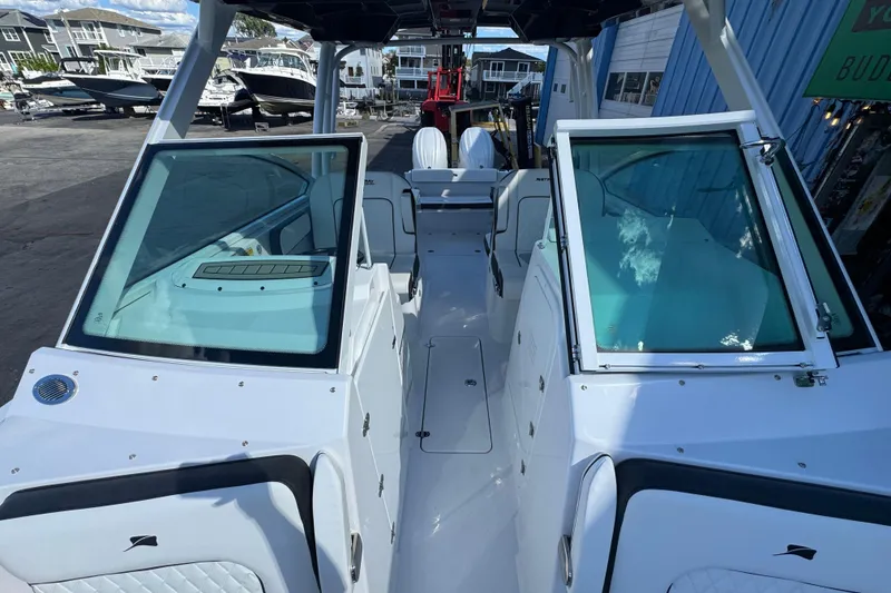 Slide: The Image of 2026 Stingray 259 DC boat interior with open deck and seating, docked at marina. - 23