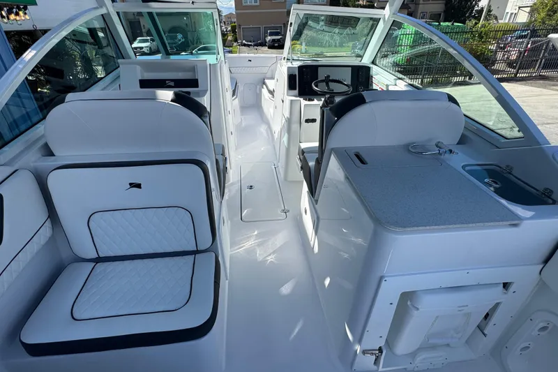 Slide: The Image of 2026 Stingray 259 DC boat interior with white seating and modern dashboard. - 6