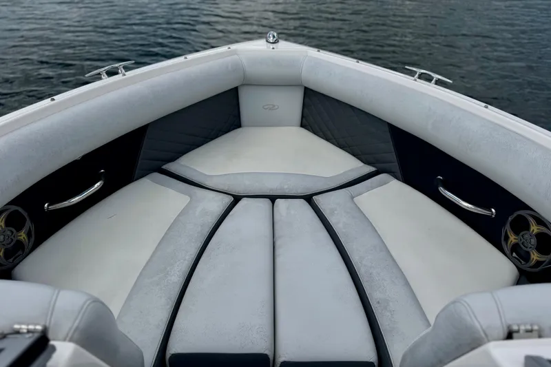 Slide: The Image of Bow seating area of a 2013 Regal 21 OBX boat on water. - 11