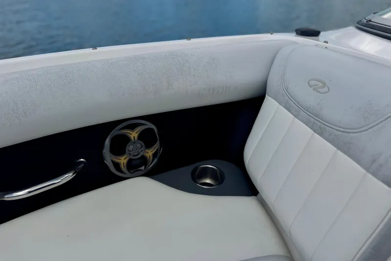 Slide: The Image of Interior of 2013 Regal 21 OBX boat with white seating and speaker detail. - 12