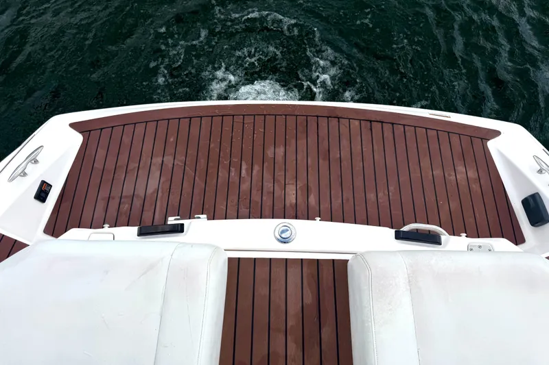 Slide: The Image of 2013 Regal 21 OBX boat deck with wooden finish, overlooking water. - 20