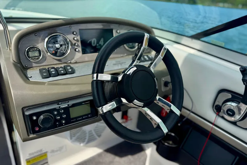 Slide: The Image of Steering wheel and dashboard of 2013 Regal 21 OBX boat, featuring modern controls. - 3