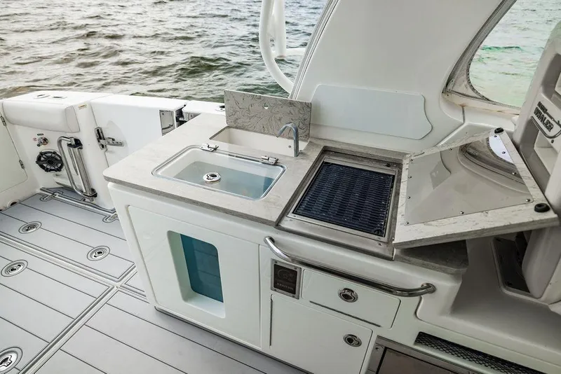 Slide: The Image of 2019 Boston Whaler 380 Realm boat kitchen area with sink and grill. - 28
