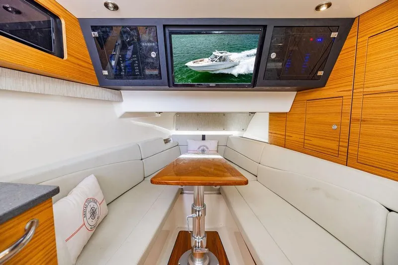 Slide: The Image of Interior of 2019 Boston Whaler 380 Realm with seating, table, and TV display. - 31