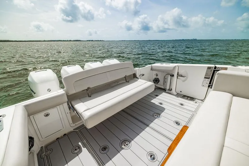 Slide: The Image of 2019 Boston Whaler 380 Realm boat interior with seating, overlooking calm ocean waters. - 6