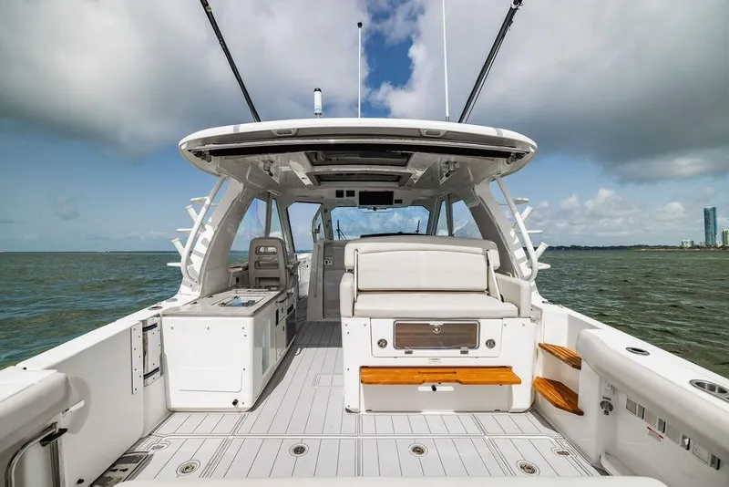 Slide: The Image of 2019 Boston Whaler 380 Realm boat interior with seating, ocean view, and clear sky. - 7