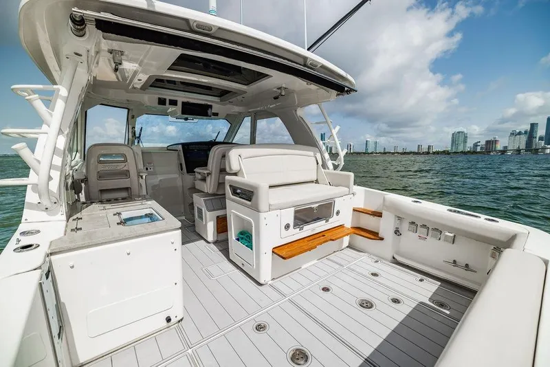 Slide: The Image of 2019 Boston Whaler 380 Realm boat interior with seating, ocean view, and city skyline. - 8