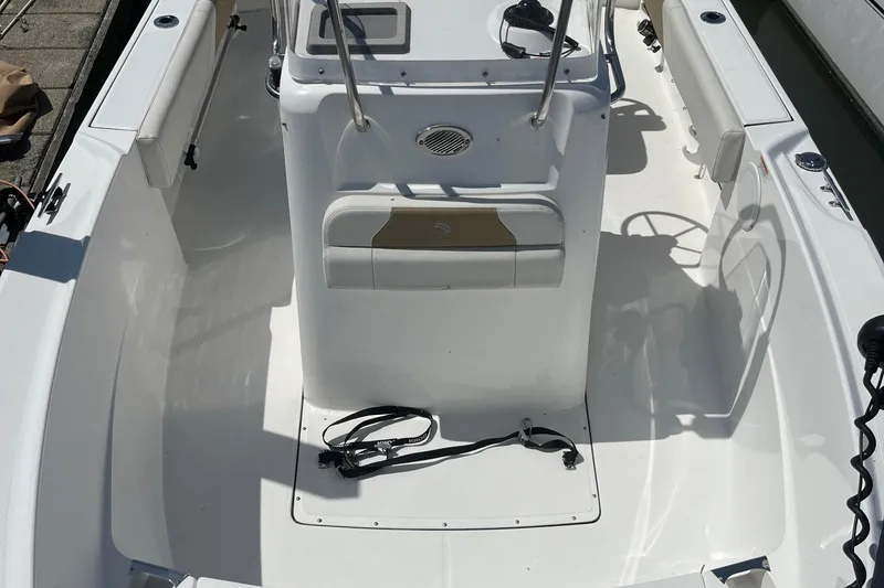 Slide: The Image of 2023 Edgewater 188CC boat interior with console and seating, docked in sunlight. - 4