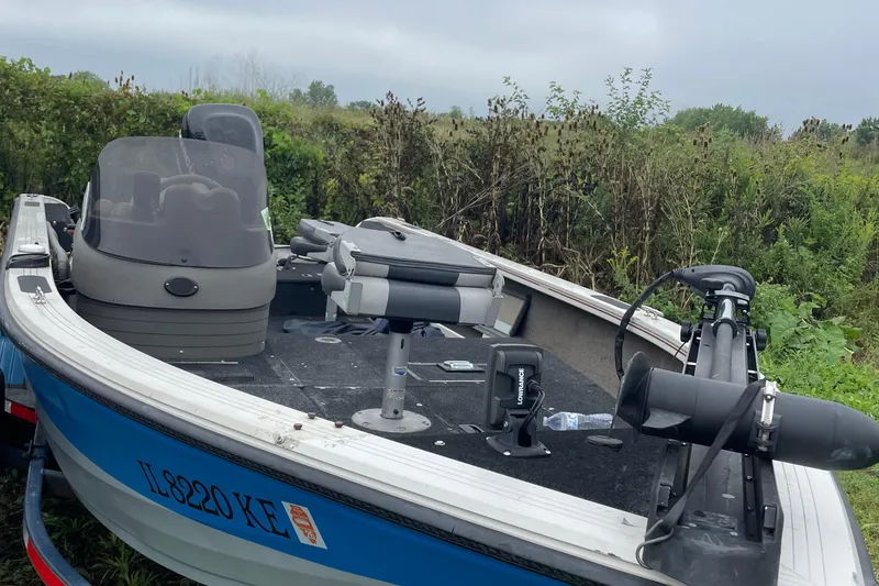 Slide: The Image of 2007 Crestliner Fish Hawk 1750 SC boat in grassy area, featuring fishing seats and equipment. - 3