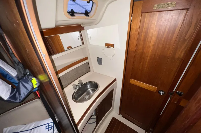 Slide: The Image of Compact bathroom interior of 1988 Hunter 333 sailboat with wooden cabinetry and stainless steel sink. - 10
