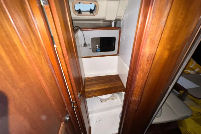 Slide: The Image of 1988 Hunter 333 yacht bathroom with wooden accents and compact design. - 11