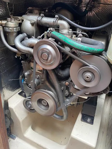 Slide: The Image of Engine of a 1988 Hunter 333 sailboat, featuring belts and hoses in a compact compartment. - 16