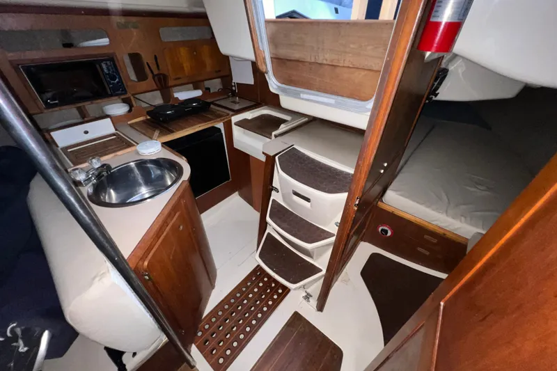 Slide: The Image of Interior of a 1988 Hunter 333 sailboat featuring a compact kitchen and cozy sleeping area. - 6