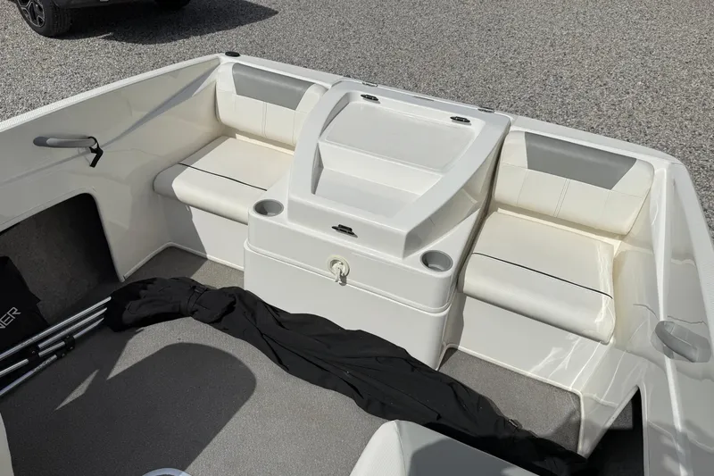 Slide: The Image of 2012 Bayliner 175 boat interior with white seating and storage compartments. - 10