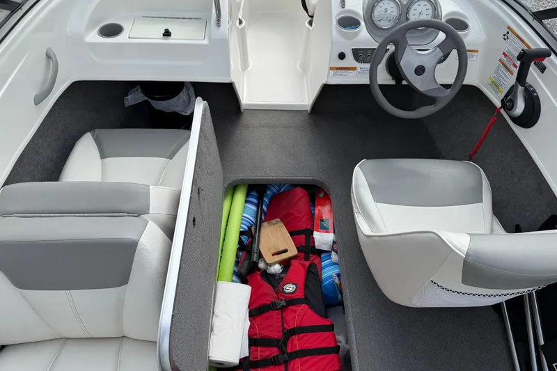 Slide: The Image of 2012 Bayliner 175 boat interior with storage compartment, life jackets, and steering wheel. - 14