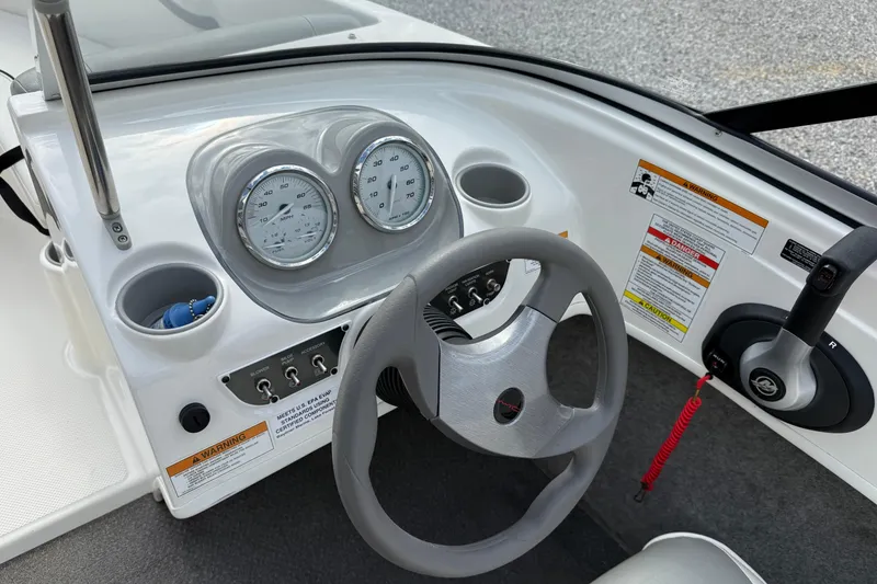 Slide: The Image of 2012 Bayliner 175 boat dashboard with steering wheel, gauges, and control panel. - 15