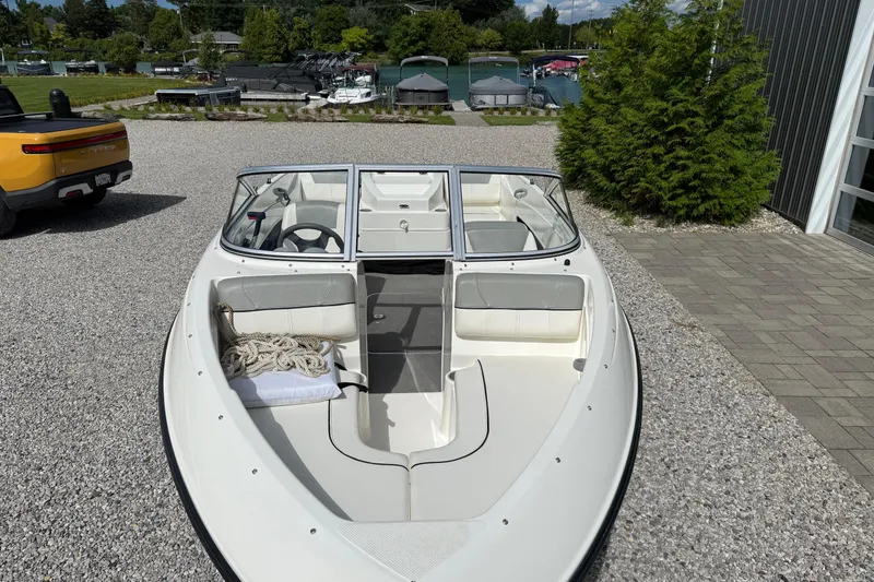 Slide: The Image of 2012 Bayliner 175 boat parked on gravel near a marina. - 8
